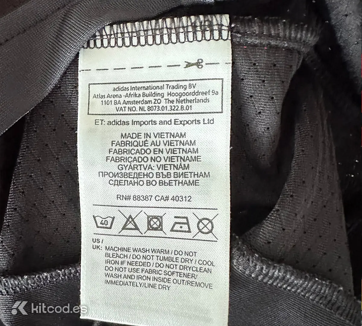 Adidas care label sewn into inner side seam showing washing instructions and manufacturing country